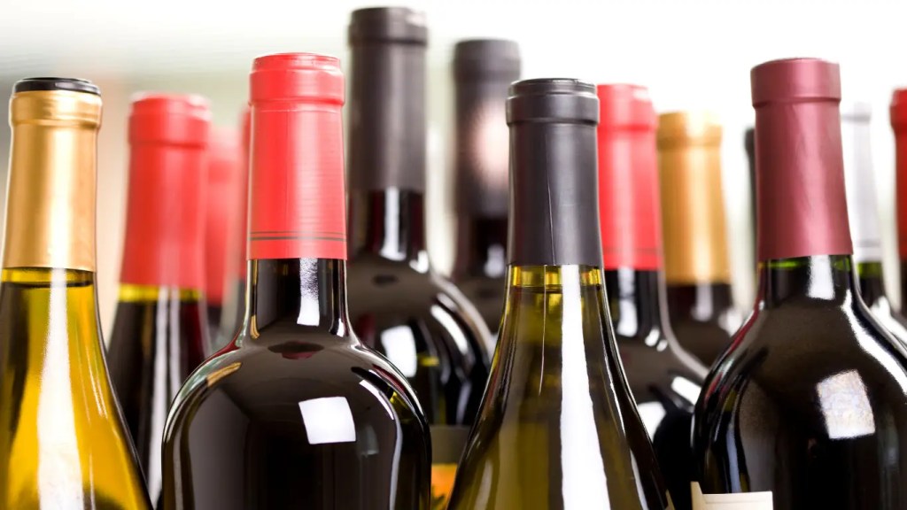 A high-density row of bulk wine bottles displaying diverse calibrated capsule closures and neck tolerances.