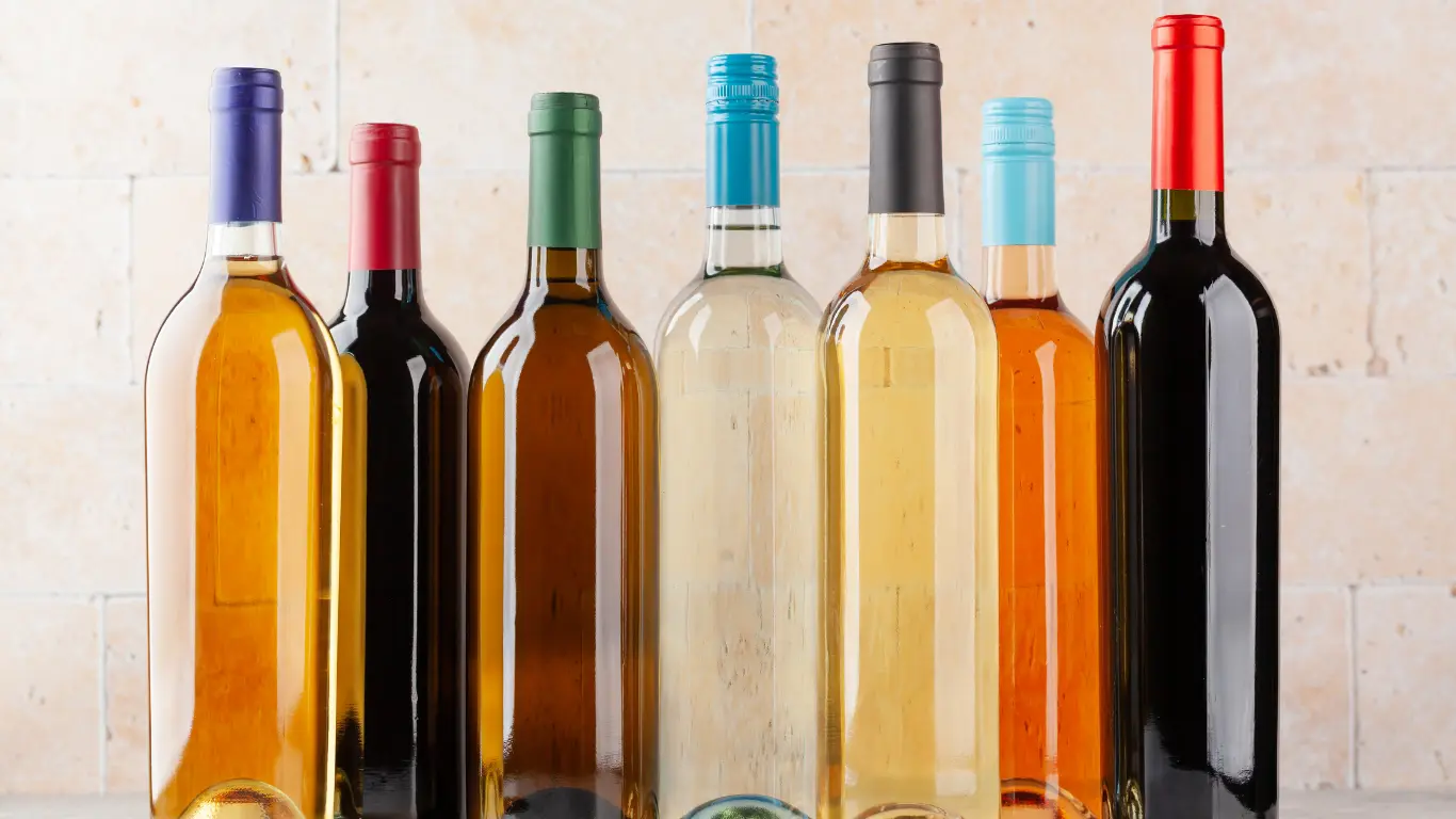 A comprehensive lineup of seven heavy-duty glass wine bottles featuring assorted colors and industrial closures.