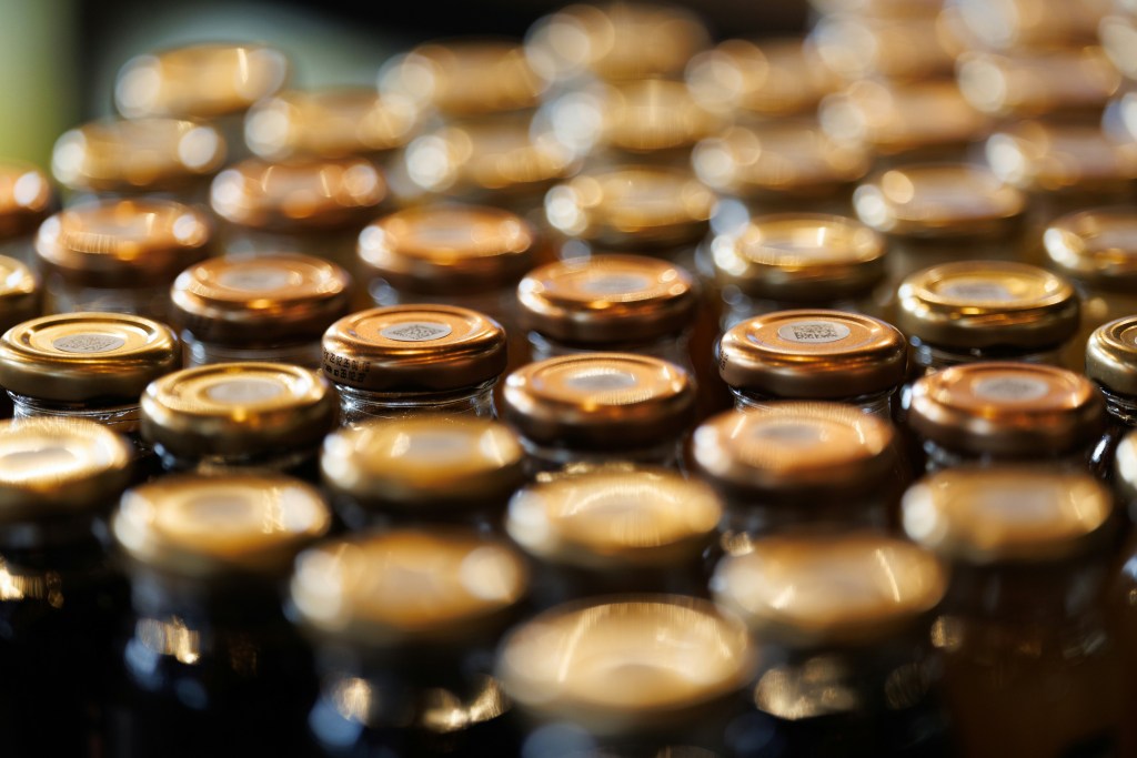 Close-up of rows of golden metal lids on glass jars with beautiful bokeh background
