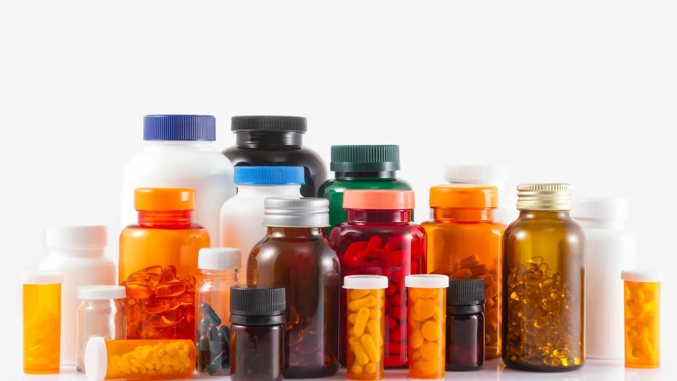 Group of amber, white, and colored plastic and glass cylinder bottles with various screw caps