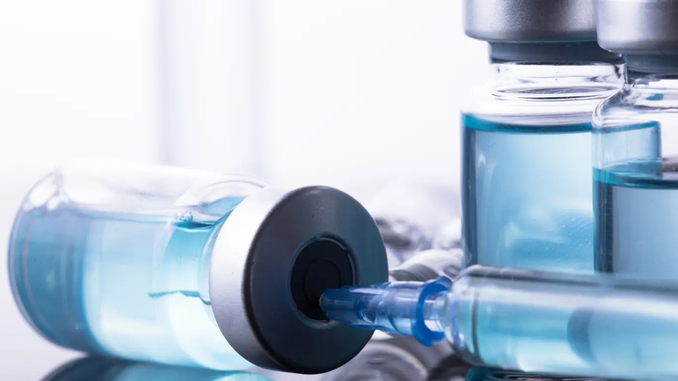 syringe drawing medication from pharmaceutical vial close-up