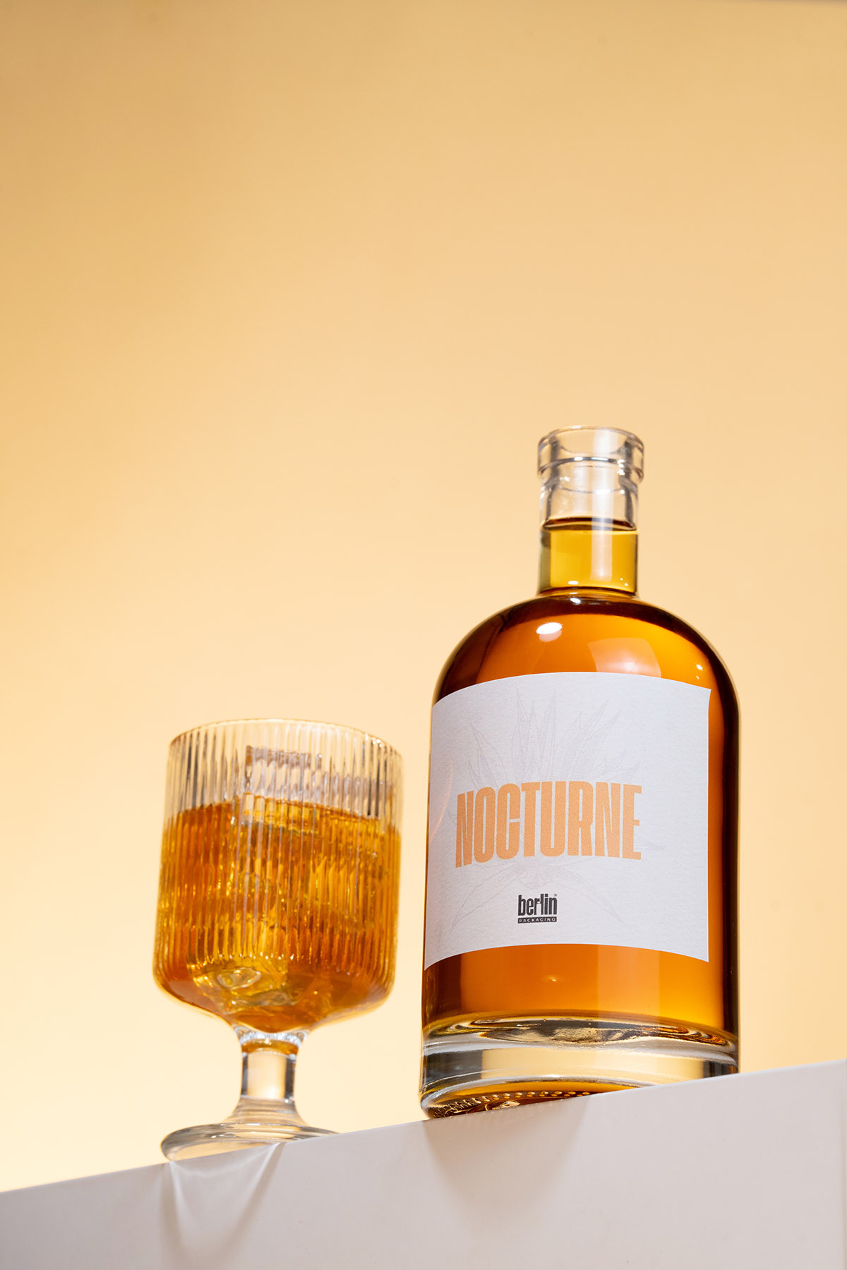 Mid-sized Nocturne clear glass spirits bottle with premium natural wood bar-top cork closure